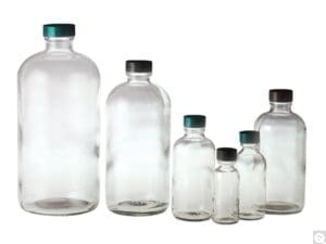 A lineup of empty glass bottles of varying sizes with caps.